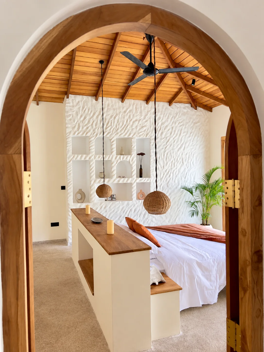 Bedroom entrance with arched timber doorway, vaulted wooden ceiling and rattan pendant lights at The Nest Sri Lanka near Hiriketiya.