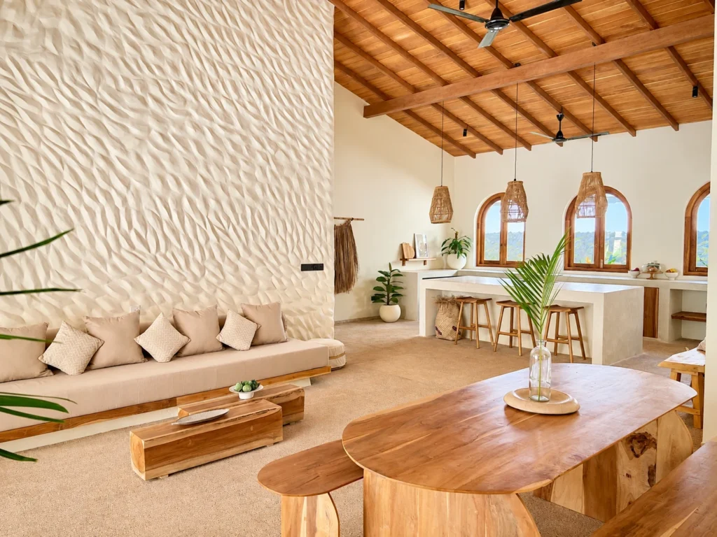 Open plan living and dining area with vaulted timber ceiling, textured feature wall and tropical design at The Nest Sri Lanka near Hiriketiya beach.