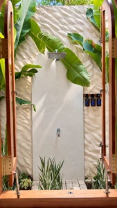 Private tropical outdoor shower surrounded by heliconia leaves at The Nest Sri Lanka